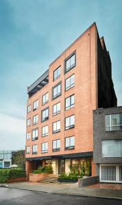 a large red brick building with a black at Nico Apartasuites in Bogotá