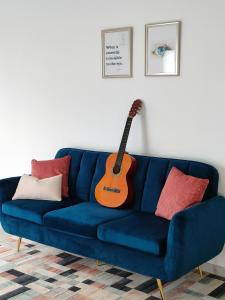 um sofá azul com uma guitarra numa sala de estar em Madeira Blue House na Calheta