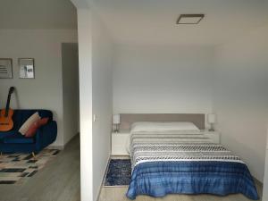Madeira Blue House في كالهيتا: غرفة نوم بسرير وكرسي ازرق