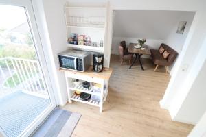een kleine woonkamer met een magnetron en een tafel bij Nordsand in Cuxhaven