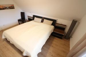 een slaapkamer met een groot wit bed met witte lakens bij Nordsand in Cuxhaven