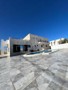 Magnifique villa avec piscine sur l’île de djerba في حومة السوق: مبنى بأرضية من البلاط ومسبح