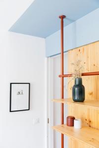 a shelf with a vase on it in a room at Hôtel Voltaire in Arles