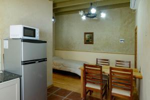 een keuken met een koelkast en een tafel met stoelen bij Apartamentos Siete Cavas in Bahía Blanca