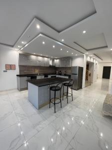 a large kitchen with a counter and chairs in it at Magnifique villa avec piscine sur l’île de djerba in Houmt Souk