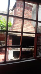 a view of a brick building through a window at Hostal Mamacoca in Purmamarca
