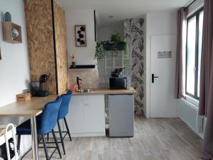 kuchnia z blatem, stołem i krzesłami w obiekcie Charmant Studio au calme 