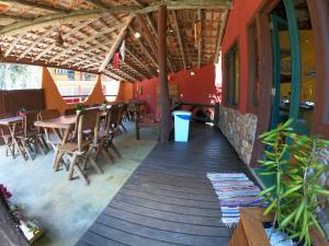 a patio with tables and chairs in a restaurant at Pousada Beleza Pura na Praia da Ferrugem in Garopaba