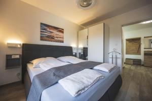 - une chambre avec un grand lit et des draps blancs dans l'établissement Ferienwohnung Tor zum Meer - Neubau mit Sauna, Fahrstuhl und Tiefgarage, à Kühlungsborn