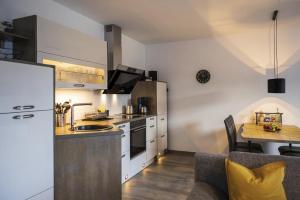 a kitchen with a sink and a table in a room at Ferienwohnung Tor zum Meer - Neubau mit Sauna, Fahrstuhl und Tiefgarage in Kühlungsborn