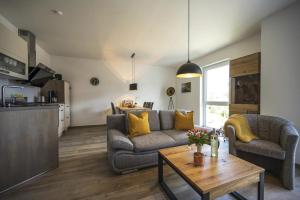 a living room with a couch and a table at Ferienwohnung Tor zum Meer - Neubau mit Sauna, Fahrstuhl und Tiefgarage in Kühlungsborn