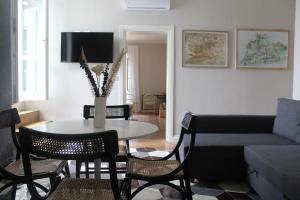 ein Wohnzimmer mit einem Tisch, Stühlen und einem Sofa in der Unterkunft Castruccio 4 - casa con vista sulla via Francigena in Fucecchio