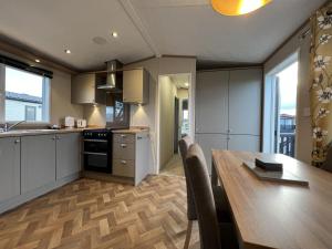 een keuken met een houten tafel en een eetkamer bij Stewarts Resort Lodge 31 in St Andrews