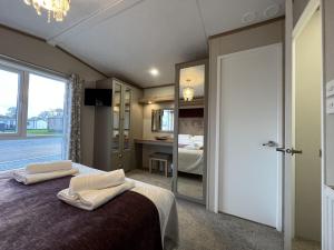 1 dormitorio con 1 cama con 2 toallas en Stewarts Resort Lodge 31 en St Andrews