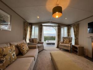 sala de estar con sofá y sillas en Stewarts Resort Lodge 31 en St Andrews
