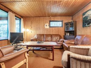 HalsにあるThree-Bedroom Holiday home in Hals 11のリビングルーム(革製家具、テーブル付)