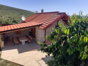 ein kleines Haus mit einem Tisch und einem Dach in der Unterkunft Patakun holiday home for 5, with heated pool in Lećevica