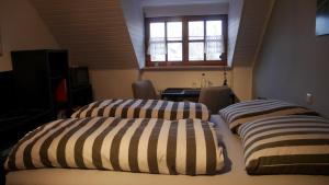 two beds with striped pillows in a room at Ruhiges Zimmer Nähe Nürnberg Messe mit Wallbox in Nuremberg