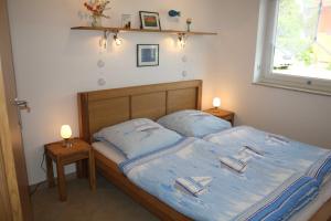 a bedroom with a bed with blue sheets and two lamps at Ruegen_Fewo 279_1 in Putbus