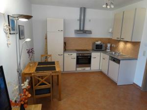 a kitchen with white cabinets and a wooden table at Ruegen_Fewo 279_1 in Putbus +21 photos