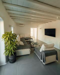 Sala de estar con 2 camas y mesa en Villa Salty, The above Alemagou experience, en Ftelia