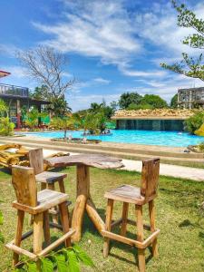 a picnic table and two chairs next to a pool at Gem's Paradise Resort in Cebu City