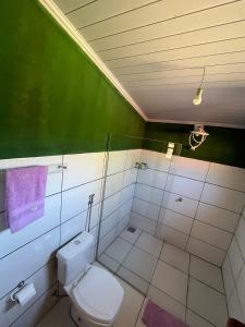 a bathroom with a toilet and a shower with purple towels at Pousada Varanda da Serra in Cavalcante