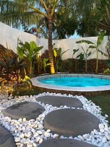 una piscina en un patio con rocas alrededor en Pousada Ilha do Vento, en São Miguel do Gostoso