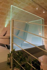 a glass shelf in a room with a couch at Tell me why Puglia in Corato