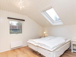 een witte slaapkamer met een bed en een raam bij Holiday home Hals CXXXI in Hals