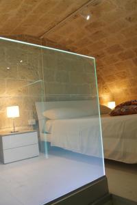 um quarto com uma cama e uma parede de vidro em Tell me why Puglia em Corato