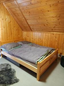 ein Schlafzimmer mit einem Bett in einem Holzzimmer in der Unterkunft Magiczny Dom w Brennej in Brenna
