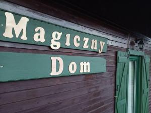 ein Schild an der Seite eines Holzgebäudes in der Unterkunft Magiczny Dom w Brennej in Brenna