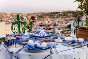 uma mesa coberta com pratos azuis e brancos de alimentos em Riad Rcif Alif Suite & SPA em Fez