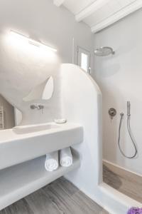 y baño blanco con lavabo y ducha. en Villa Salty, The above Alemagou experience, en Ftelia