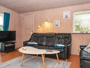 a living room with a leather couch and a table at Holiday home Knebel LVII in Knebel