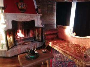 a living room with a fireplace and a couch and a table at La stanza nel parco in Anguillara Sabazia