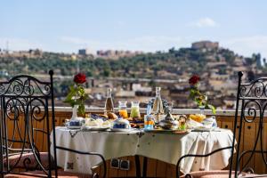 uma mesa com comida numa varanda com vista em Riad Rcif Alif Suite & SPA em Fez