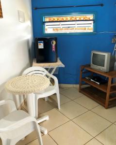 a table and chairs in a room with a tv at Pousada Canto do Mar Ilha Grande in Praia de Araçatiba