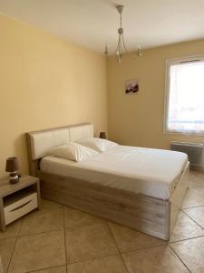 a bedroom with a large bed with white sheets at Les locations Cinaureva "Les Îles d'Or" in La Londe-les-Maures