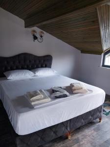 uma cama com lençóis brancos e toalhas em ZEMAHOTEL em Büyükçekmece