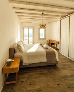 1 dormitorio con 1 cama grande y 1 mesa en Villa Salty, The above Alemagou experience, en Ftelia