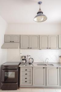 a kitchen with white cabinets and a black stove top oven at Anden Espejo in Mendoza