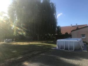 un appareil blanc assis au soleil dans une cour dans l'établissement Belle longère - proche circuit 24h, à Roézé-sur-Sarthe