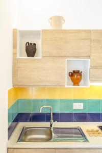 a kitchen with a sink and colorful tiles at TORRETTA CORRICELLA- Punta Pizzaco in Procida