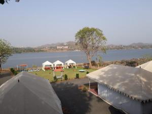 a group of tents in front of a lake at River View Tent Resort in Garudeshwar