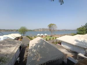 a group of white tents and a body of water at River View Tent Resort in Garudeshwar
