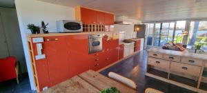 uma grande cozinha com armários vermelhos e uma mesa em Cozy house at the lake em Nazareth