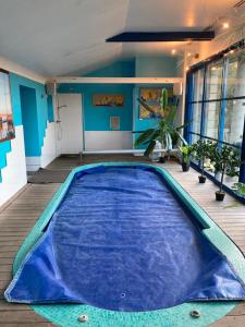 a large blue swimming pool in the middle of a room at Ar Couette in Le Bono