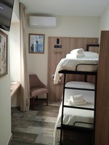 a small room with two bunk beds and a chair at Hospedium Hostal Temático Desde La Judería in Arjona